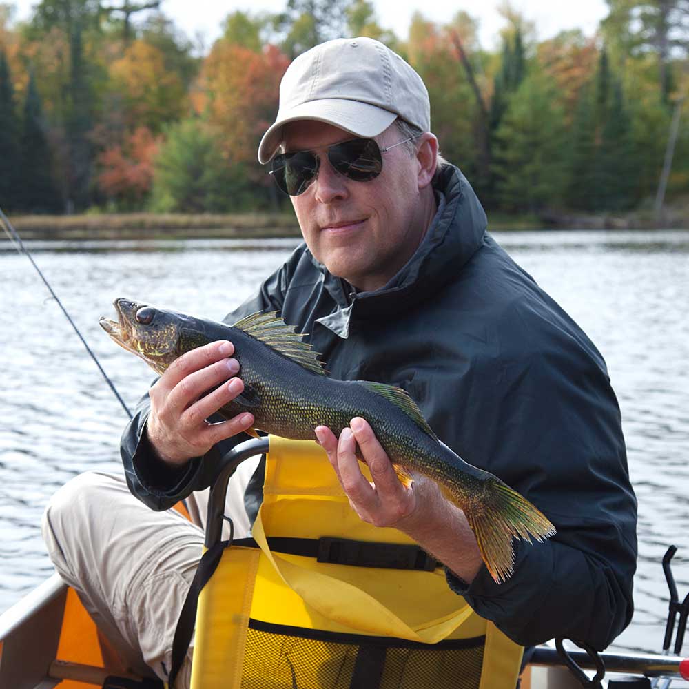 Happy Fisherman Holds Up A Walleye On A Northern M