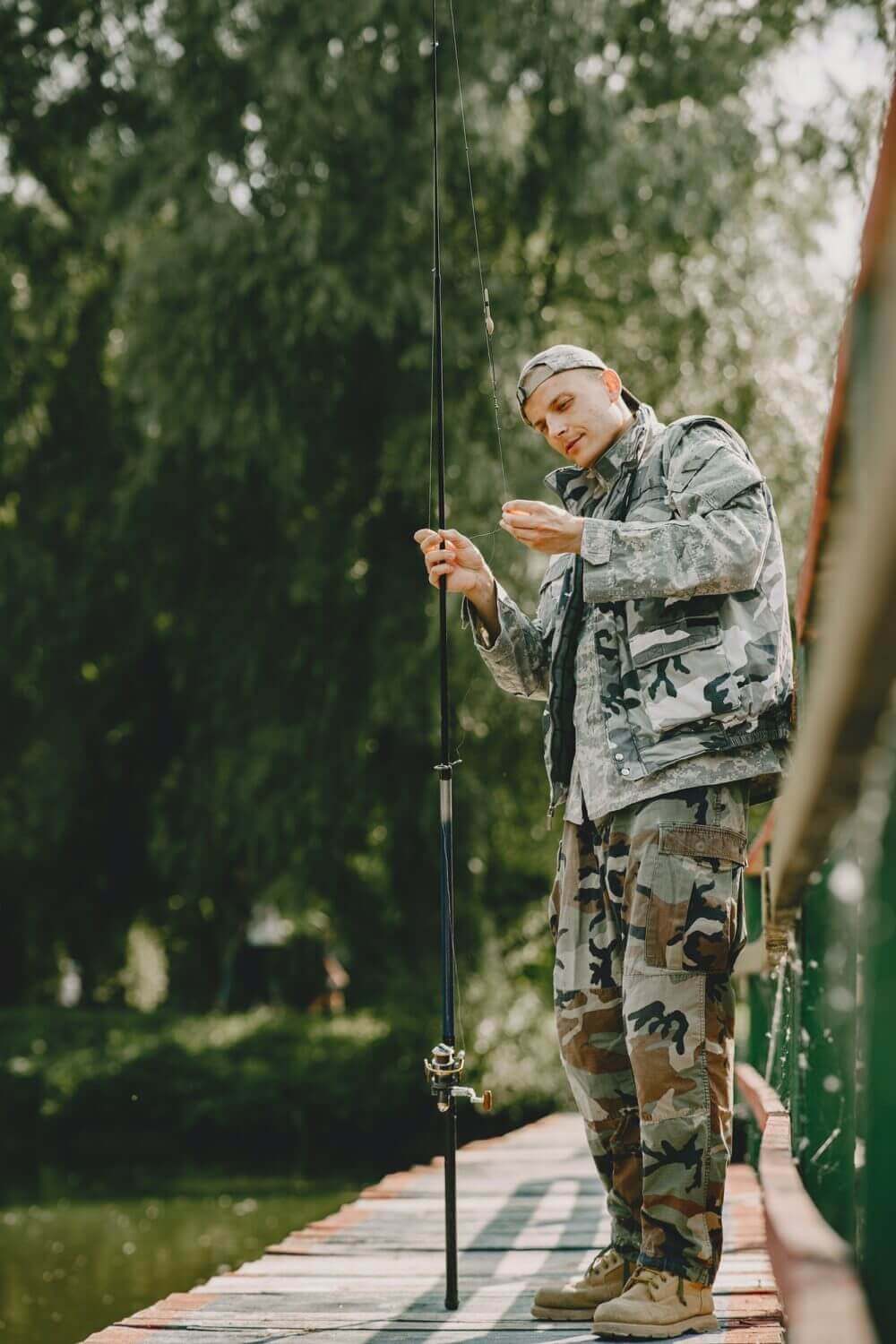 Man Fishing And Holds The Angling Rod 1 E1625801374590